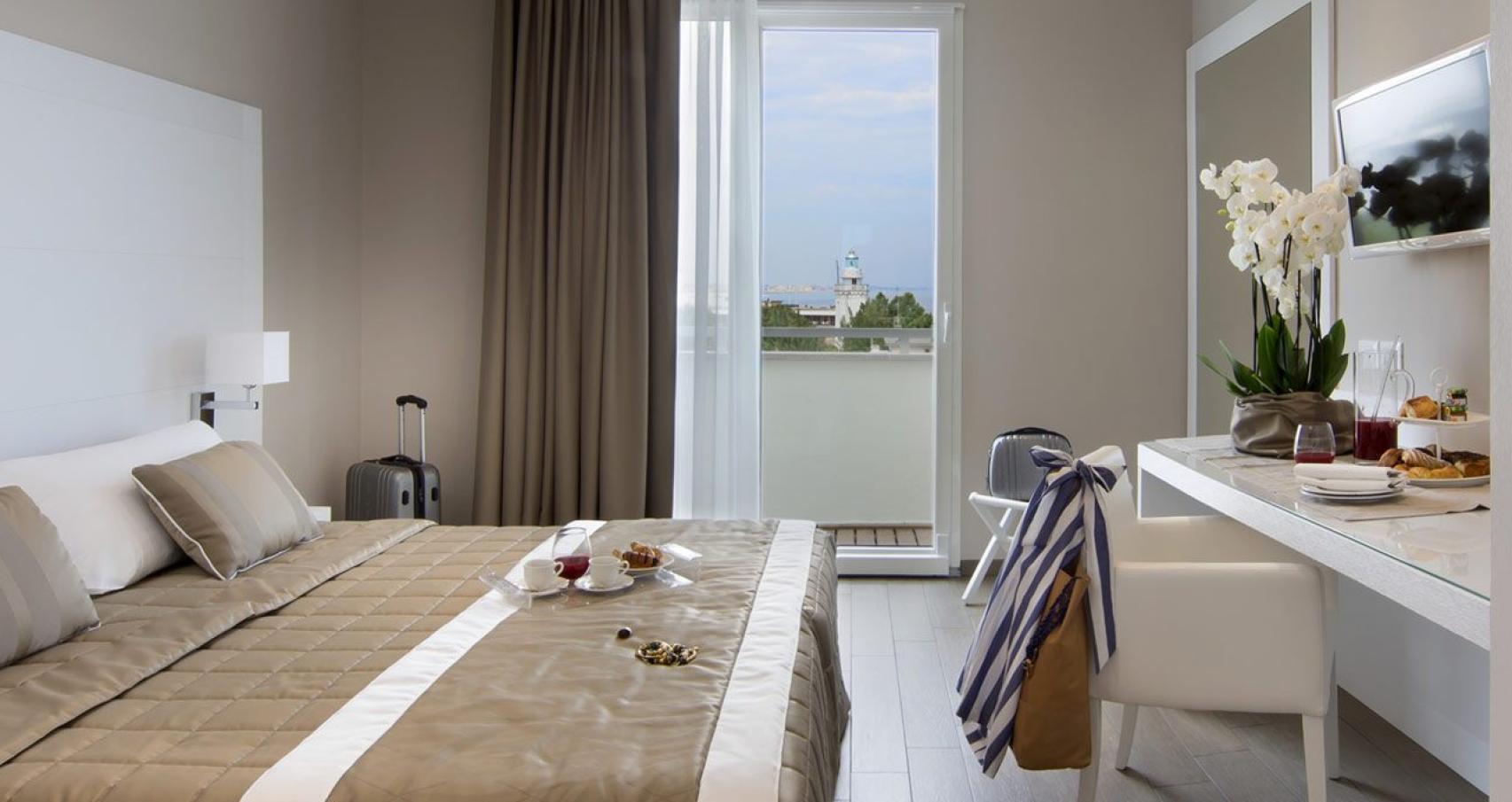 Elegante camera d'hotel con vista sul mare e colazione servita in camera.
