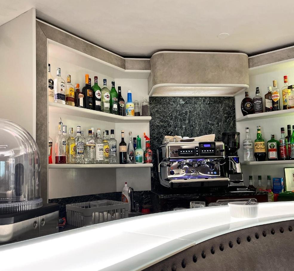 Bar with liquor shelves and an espresso machine.